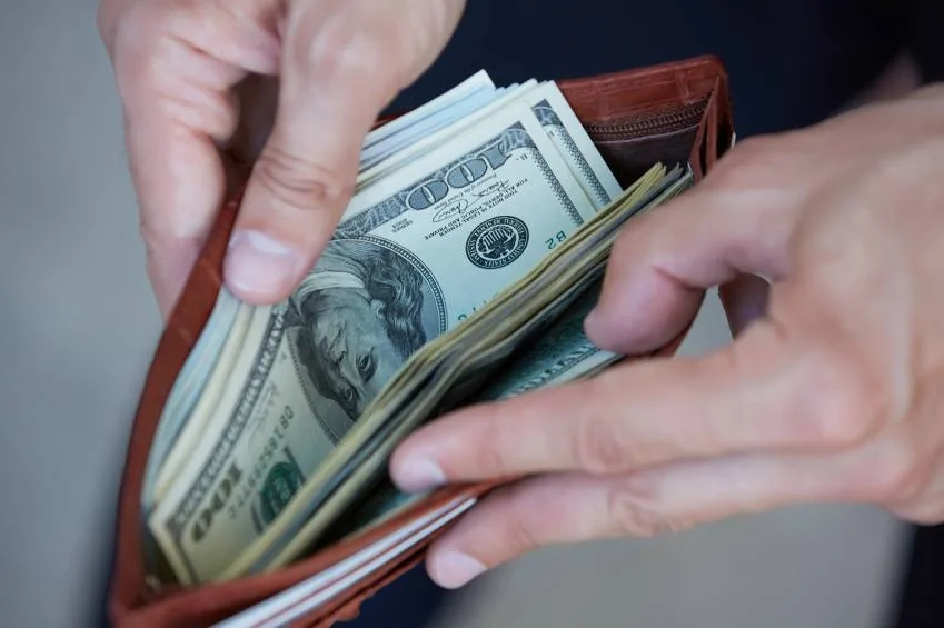 man-holding-a-purse-with-money-closeup.webp