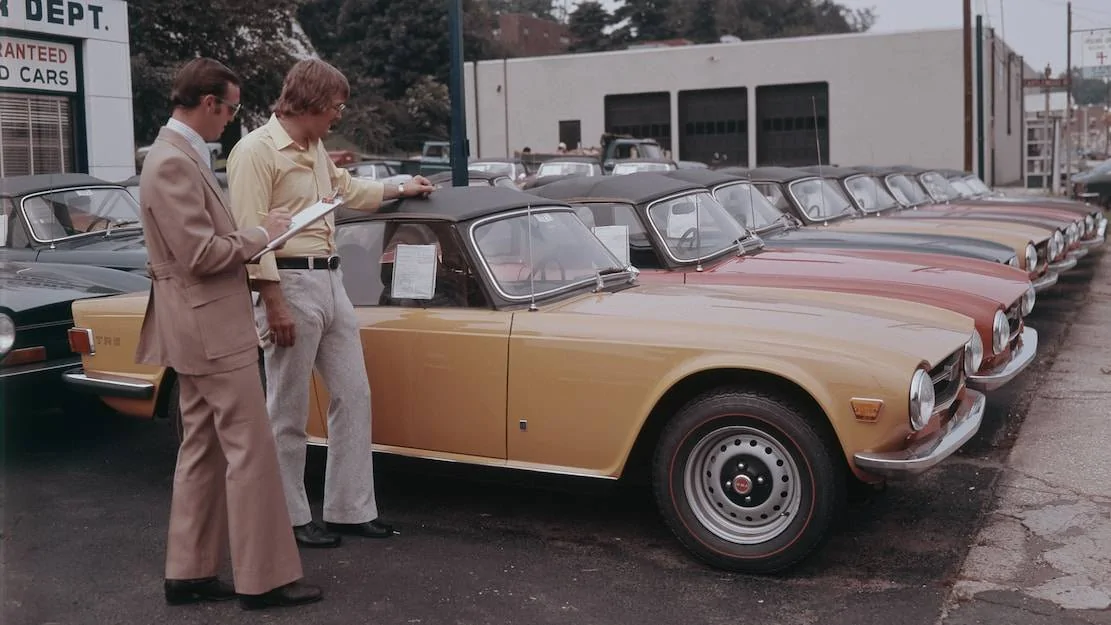 n-checks-out-a-line-of-Triumph-TR6s-at-dealer-1972.webp