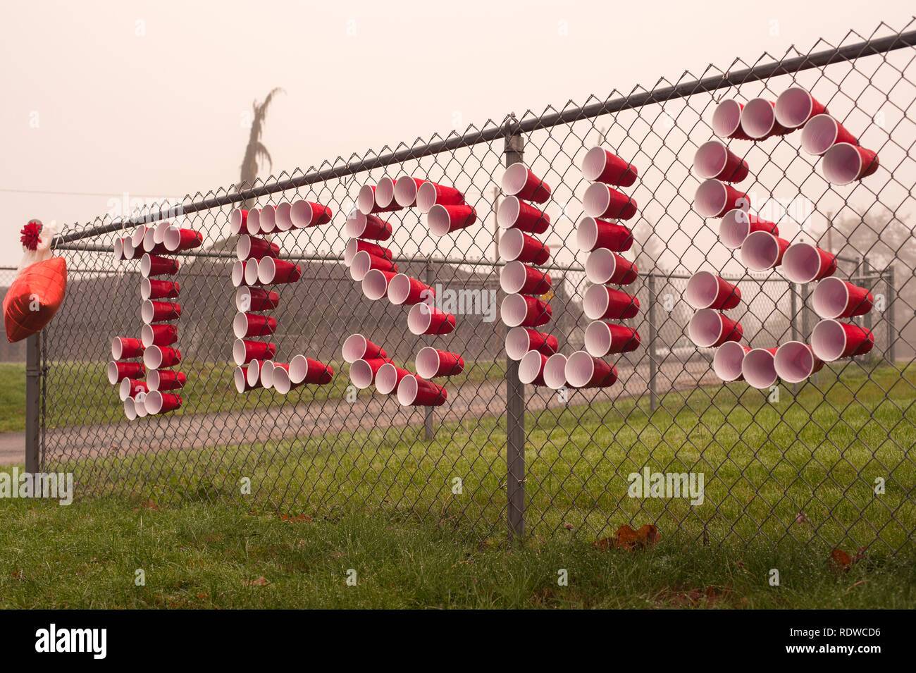 red-cups-spelling-jesus-on-chain-link-fence-RDWCD6.jpg