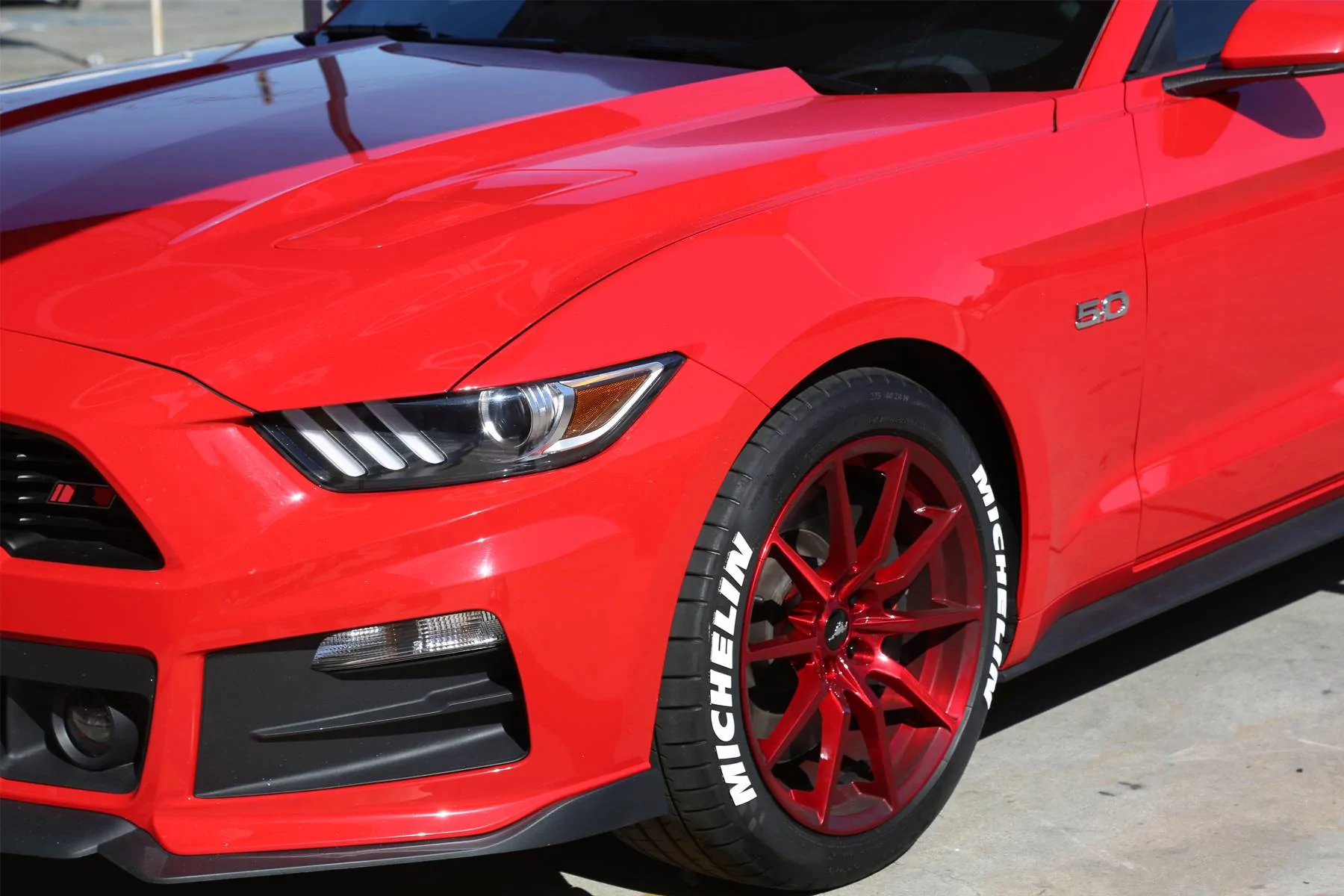 white-michelin-tire-stickers-red-ford-mustang-front-side-view.webp
