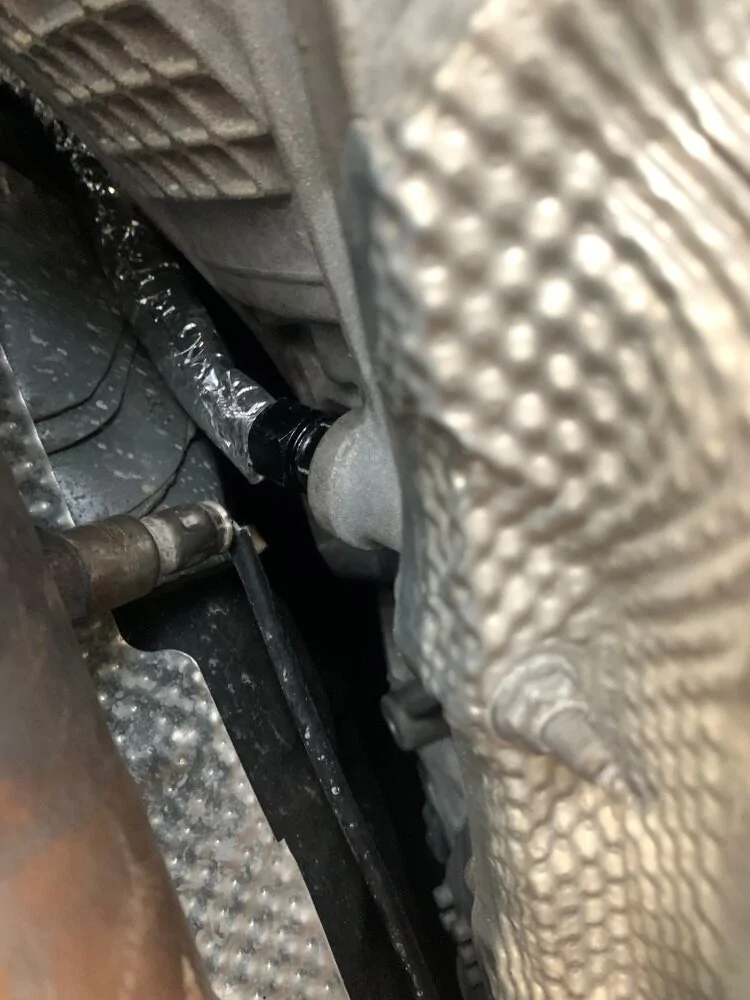 Dipstick Hose Routing near Transmission and Catalytic Converter.webp