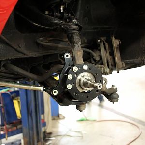 The bronze strut rod is viewable. Pete at Samaritan Tire had to drill out and tap the stock disc spindles to mount this caliper holder. The original s